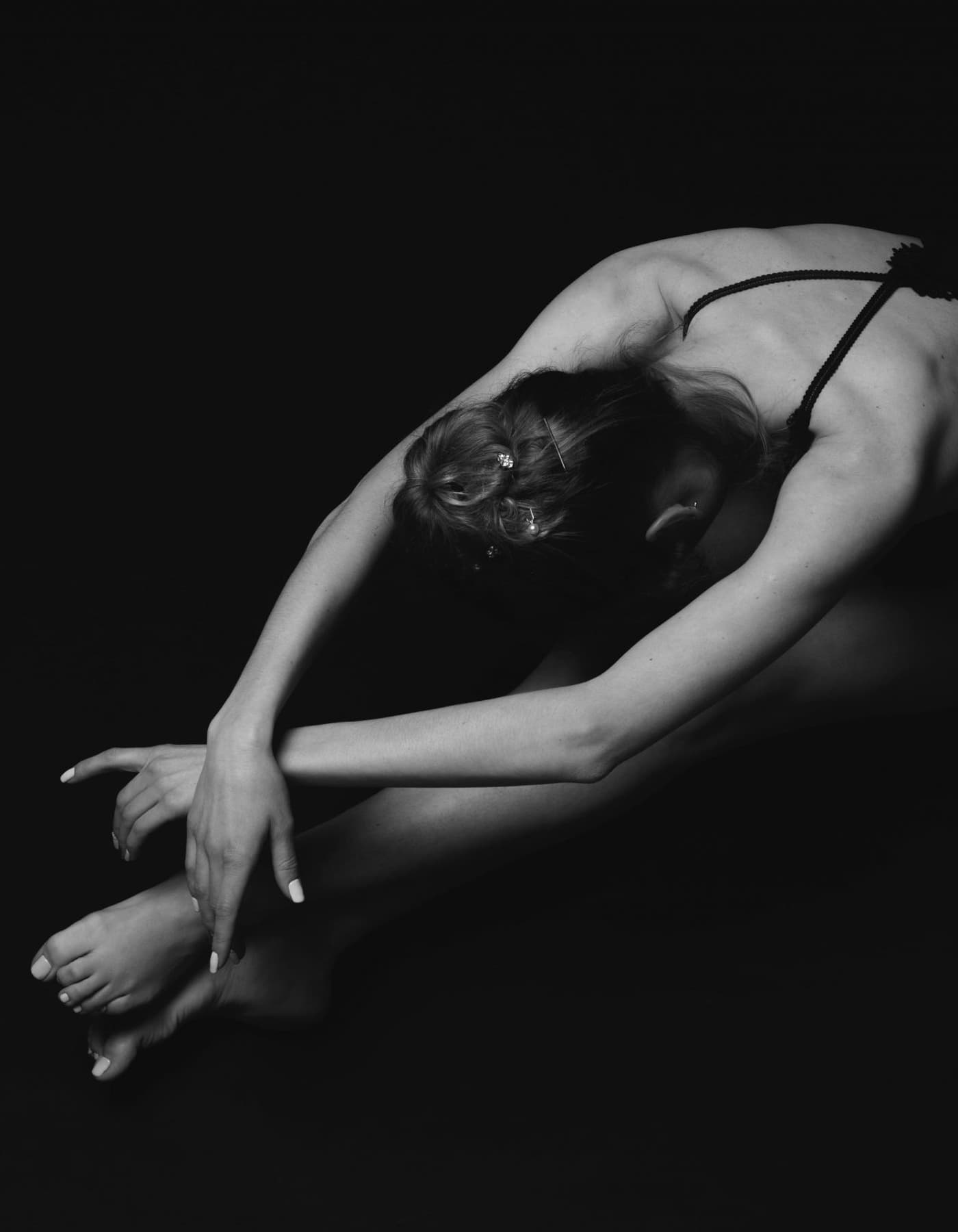 Pointe dancer seated in a boutique fitting space with warm window light.