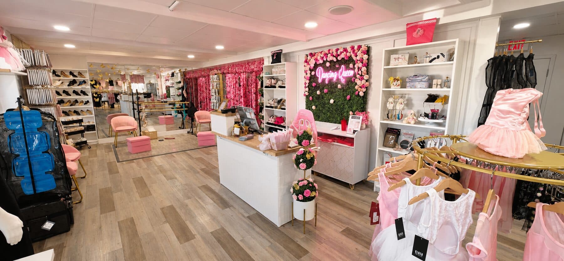StepUp Pointe Area with a floral feature wall, neon sign, and checkout counter.