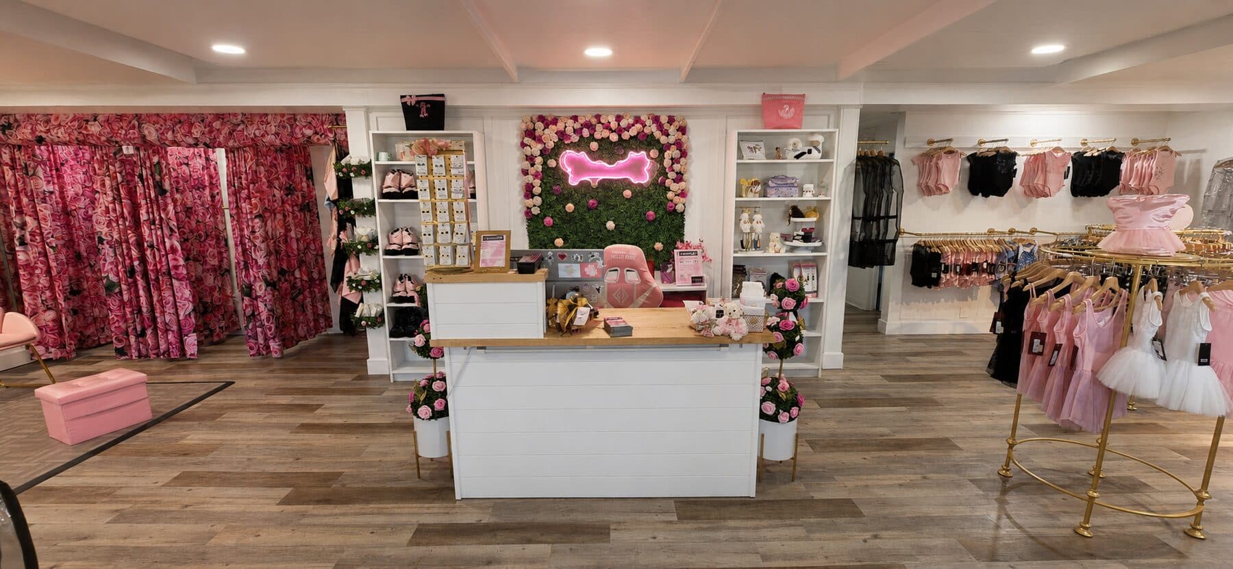 StepUp boutique interior centered on the service counter with a pink floral feature wall.